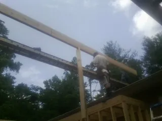 Carpenter setting a ridge beam over a new addition frame — Ice Dam Removal by Roofing Brothers in Intercourse
