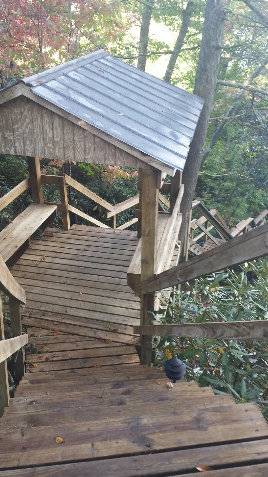 Metal roofed shelter over wooden steps on a wooded walkway — Skylight Repair & Installation work by our crew in Intercourse