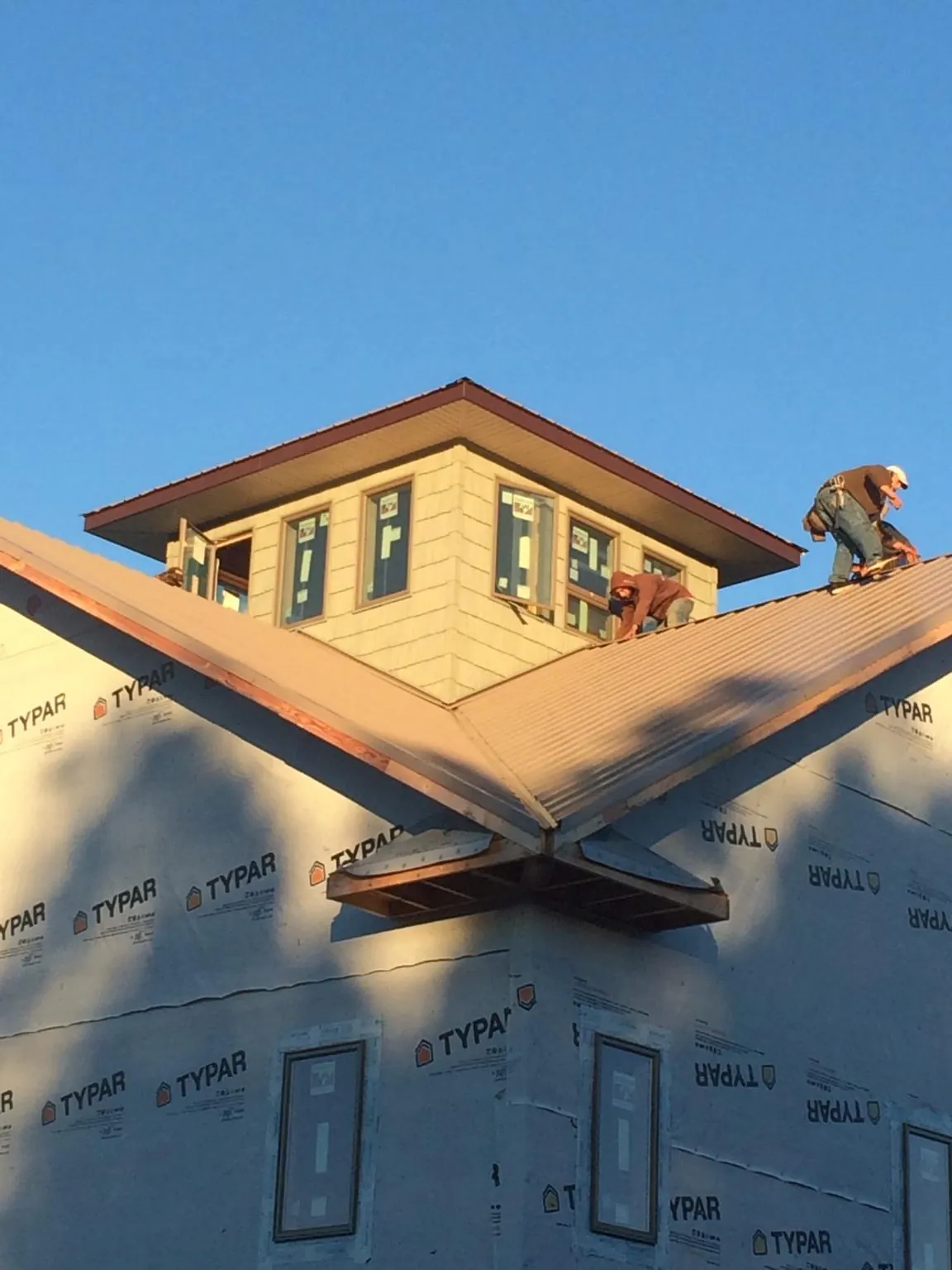 Roofers working around a rooftop cupola on a new metal roof at sunset — Roof Waterproofing in Intercourse by Roofing Brothers